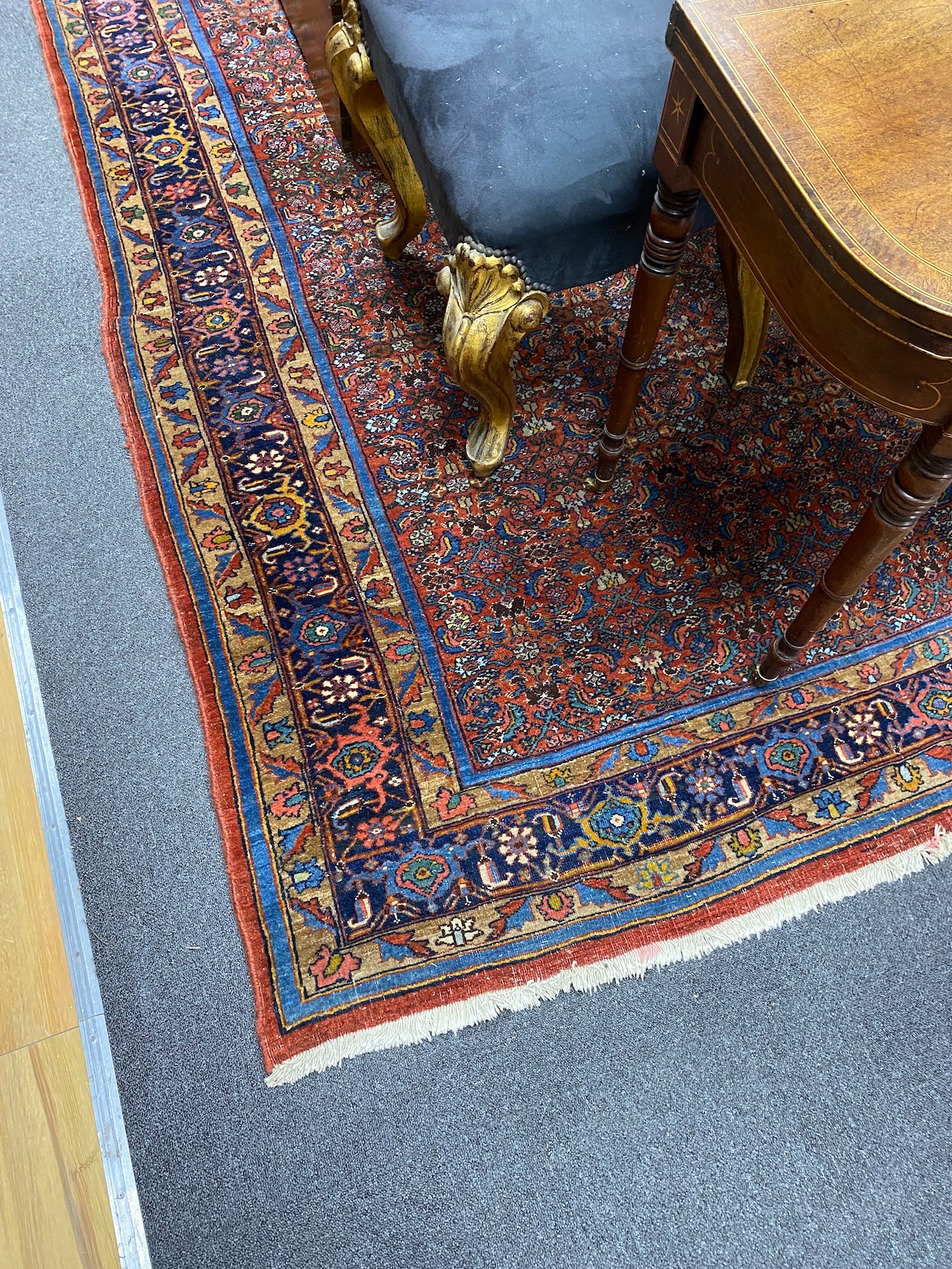 A North West Persian red ground carpet with dense floral field within a triple border, 360 x 250cm